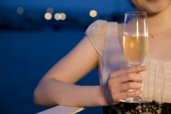 テラスでシャンパンを飲む女性の手元