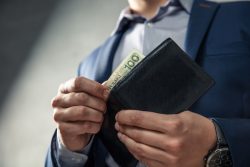 男性がお金を財布から出すシーン