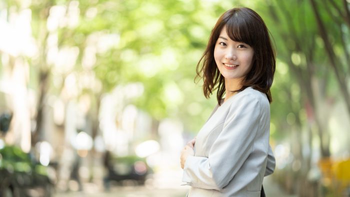 portrait of asian businesswoman walking in sidewalk