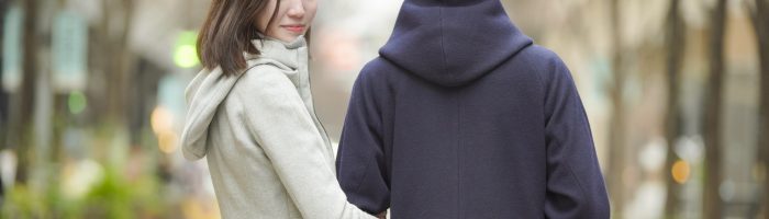 街を歩くカップルと振り返る女性