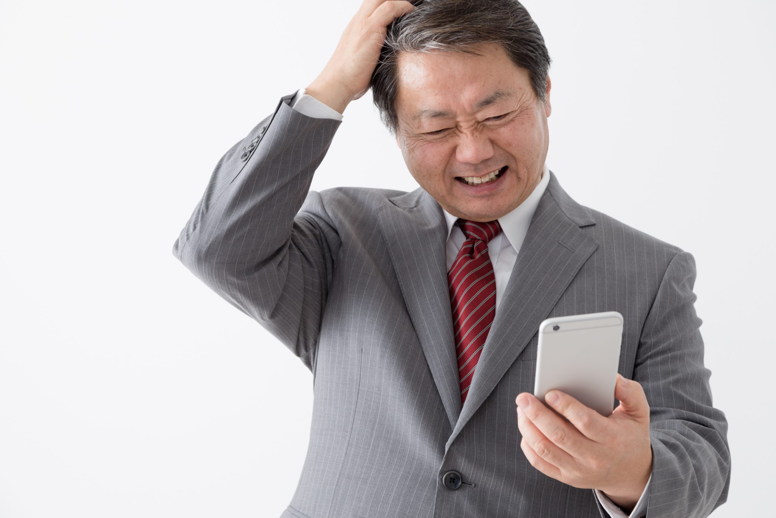 携帯電話を持つビジ頭をかく中年男性